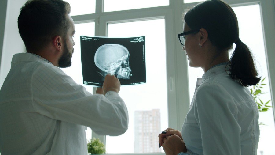 Healthcare professionals reviewing a patient’s brain X-ray in a clinical setting
